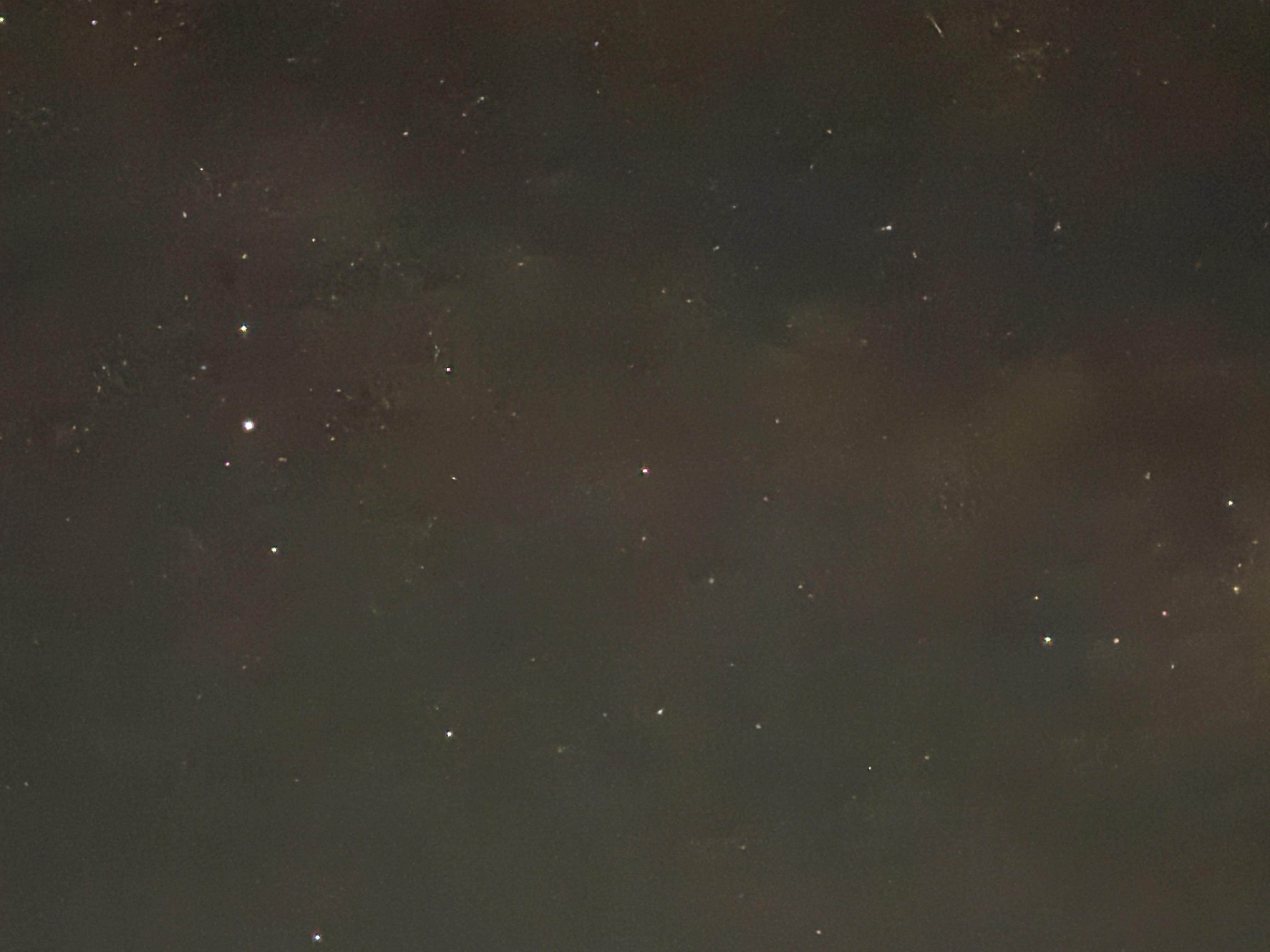 A dark night sky with scattered white stars visible against a black background.