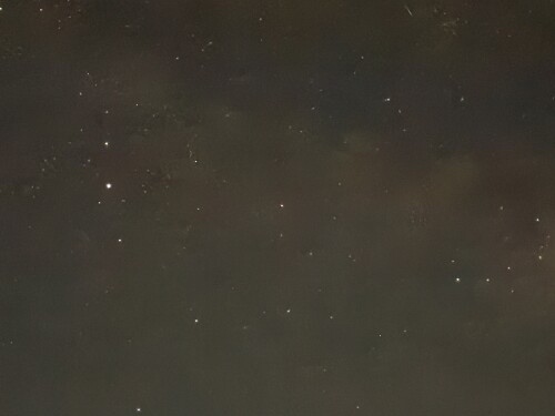 A dark night sky with scattered white stars visible against a black background.
